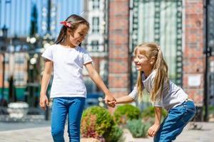 Two beautiful little girls outdoor in the playground at summer time photo