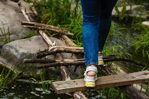 Woman walk on stepping stones across the river. photo