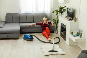 Young woman using vacuum cleaner at home photo