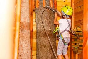 Happy little girl climbing on outdoor playground photo