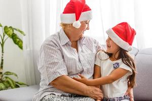 abuela con nieta en sombrero de santa foto