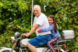 feliz abuelo y su nieta cerca de la bicicleta sonriendo foto