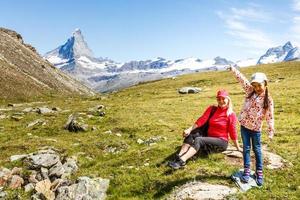 Happy hiker woman and girl at mountains lake photo