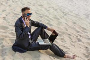 Businessman sitting alone in the empty desert photo