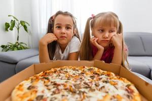 little bored girls eating pizza at home photo