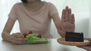 la mujer delgada de belleza confunde la comida alta en calorías. buena comida saludable. adelgazar, equilibrar, controlar, reducir grasa, bajar calorías, rutinas, ejercicio, dieta. video