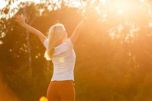 Free Happy Woman Enjoying Nature. Beauty Girl Outdoor. Freedom concept. Beauty Girl over Sky and Sun. Sunbeams. Enjoyment