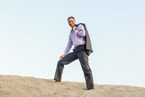 Happy businessman in a suit in the desert photo