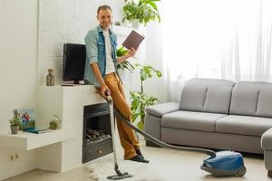 Coronavirus pandemic. A man with a vacuum cleaner in his apartment. Home Office. Quarantine. Remote work. A man in a business shirt and underpants holds. photo