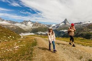 Happy hiker woman and girl at mountains lake photo