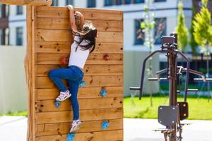 attractive little girl on outdoor playground equipment photo