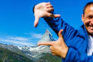 Hiker poses in front of mountain peaks range hiking backpacker old older aarp strong strength vital energetic landscape photography portrait background colorful adventure retired retirement outdoor photo