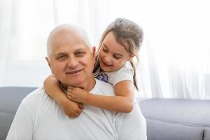 retrato de abuelo con nieta relajándose juntos en el sofá foto