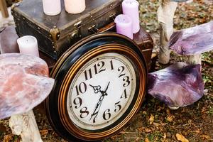 Vintage black alarm clock on autumn leaves. Time change abstract photo. Daylight saving time. photo