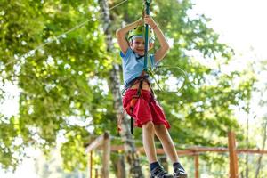 happy little children in a rope park on the wood background photo