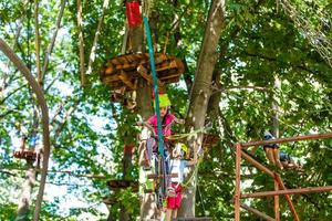 happy little children in a rope park on the wood background photo