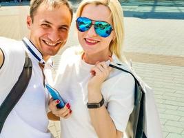 young couple handsome brunette man and beautiful woman in sportswear doing selfie on smartphone during street workout, healthy fit lifestyle. photo