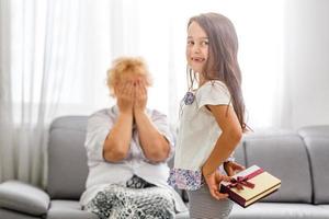 granddaughter gives grandmother a gift photo