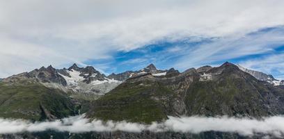 Hiking in the swiss alps with flower field and the Matterhorn peak in the background. photo