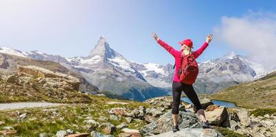 Woman on mountain top of mountain landscape around lake and blue sky. photo