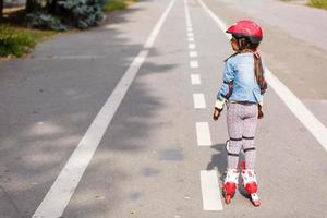 little girl rollerblading along the tracks photo