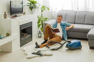 Coronavirus pandemic. A man with a vacuum cleaner in his apartment. Home Office. Quarantine. Remote work. A man in a business shirt and underpants holds. photo