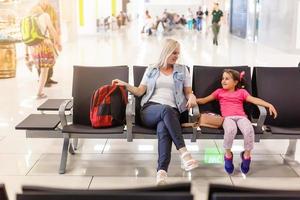 Mom and child are waiting for their plane at the airport. Passengers are waiting for their transport in the station photo