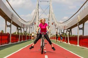 Woman riding bicycle with her legs in the air photo