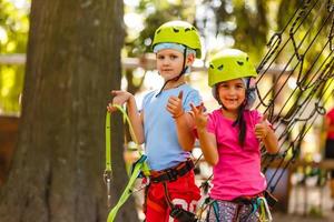 happy little children in a rope park on the wood background photo