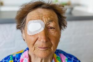 una persona mayor con vendaje en los ojos foto