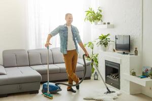 Coronavirus pandemic. A man with a vacuum cleaner in his apartment. Home Office. Quarantine. Remote work. A man in a business shirt and underpants holds. photo