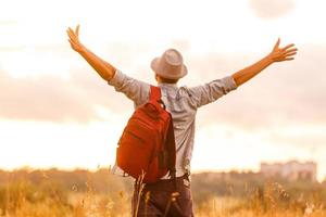 Getting away from it all. Man in open field relaxing looking at the beautiful view. photo