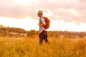 Getting away from it all. Man in open field relaxing looking at the beautiful view. photo