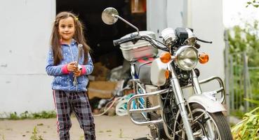 niñita reparando una motocicleta, estudiante de mecánica de motos foto