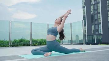 Slim beautiful Asia woman practicing yoga on the balcony of her condo. Asian woman doing exercises in morning. balance, meditation, relaxation, calm, good health, happy, relax, healthy lifestyle. video