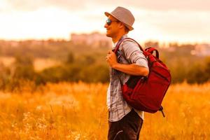 Getting away from it all. Man in open field relaxing looking at the beautiful view. photo