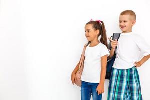 Children's fashion. Modern boy and girl posing together at studio. Education. photo