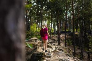 stylish hipster woman with backpack looking at amazing woods and mountains in summer, travel concept, space for text photo