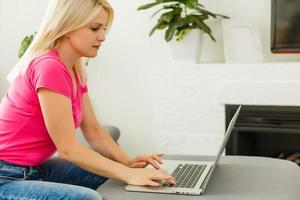young woman with laptop works at home photo