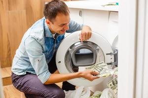 Female putting money into washing machine, closeup photo