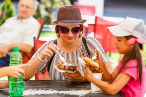 mother and children eating bubble waffle with ice cream photo