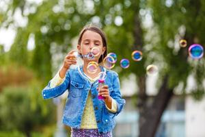 Little girl blowing soap bubbles photo