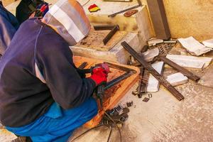 Man working with grinder saw, close up view on tool. Electric saw and hands of worker with sparks. Worker cutting metal with grinder. photo