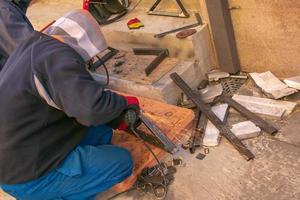 Man working with grinder saw, close up view on tool. Electric saw and hands of worker with sparks. Worker cutting metal with grinder. photo