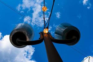 Close up of an Edison-style filament on a light bulb against a cloudy sky. Energy crisis. photo