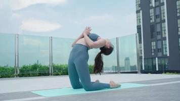 Slim woman practicing yoga on the balcony of her condo. Asian woman doing exercises in morning. balance, meditation, relaxation, calm, good health, happy, relax, healthy lifestyle concept video