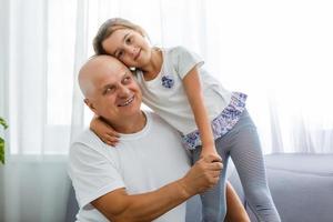 retrato de abuelo con nieta relajándose juntos en el sofá foto