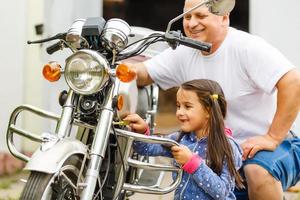 feliz abuelo y su nieta cerca de la bicicleta sonriendo foto