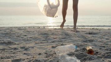 ahorrar agua. los voluntarios recogen basura en la playa y las botellas de plástico son difíciles de descomponer para evitar dañar la vida acuática. tierra, ambiente, planeta verde, reducir el calentamiento global, salvar el mundo video