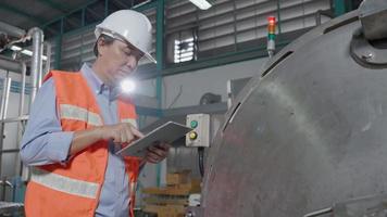 Machine or maintenance engineers inspect machines and sterilizers in factories or manufacturing industries and write down the information on tablet. Boiler, retort, appearance check, function test. video